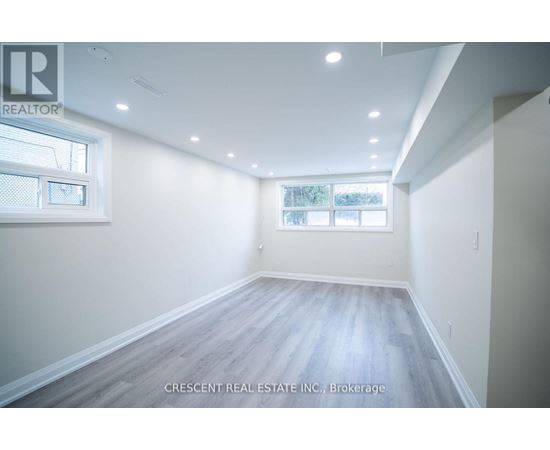 A spacious room with a window and wooden flooring.