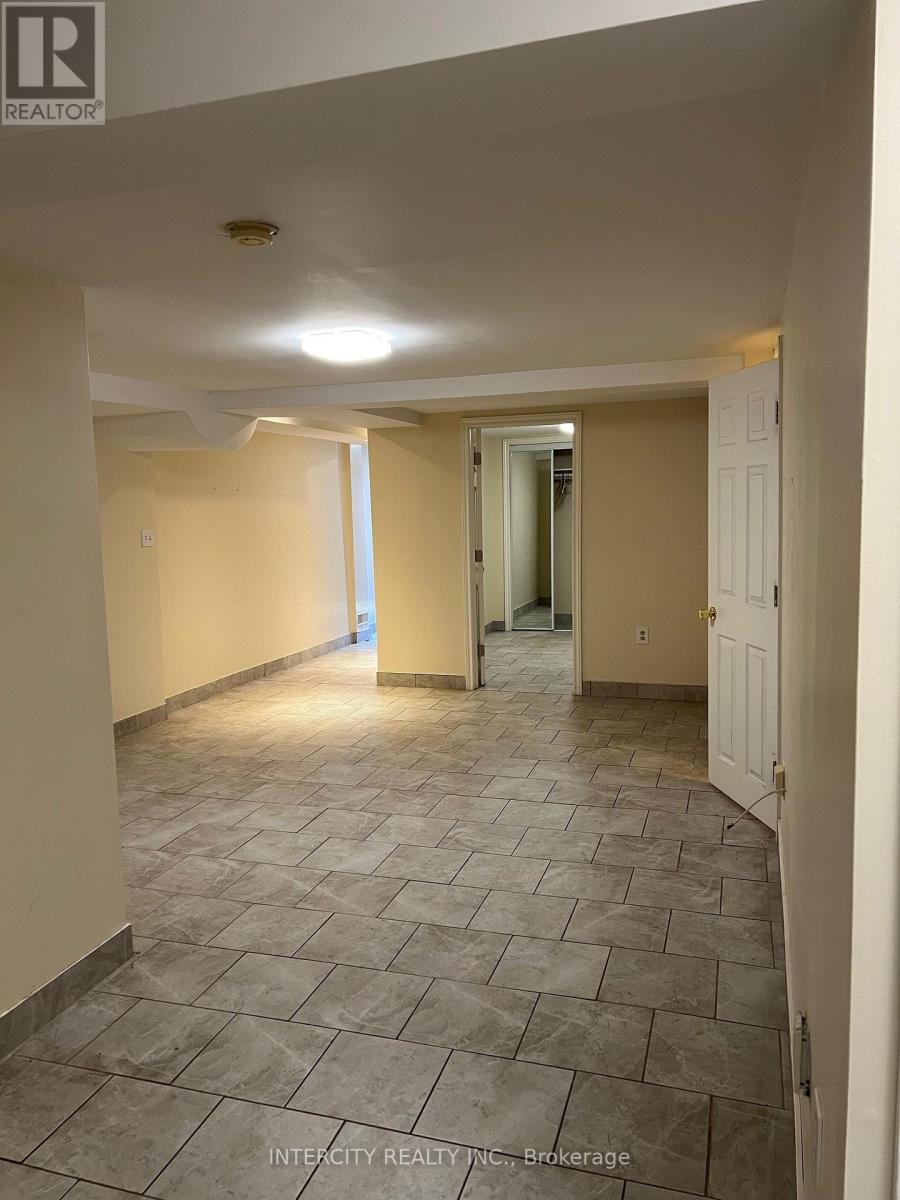 A hallway with tiled flooring and white walls.