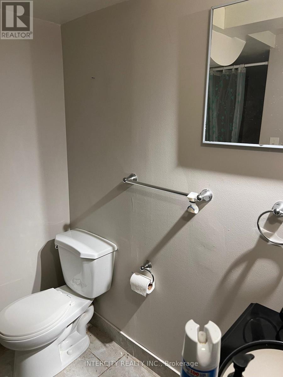 A white toilet in a bathroom with a mirror above it.