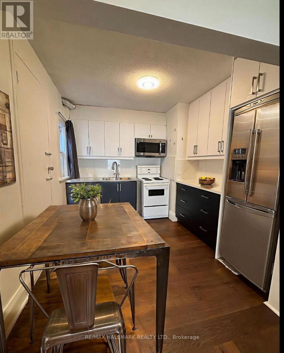 A kitchen with a table and chairs in the foreground and a refrigerator in the background.