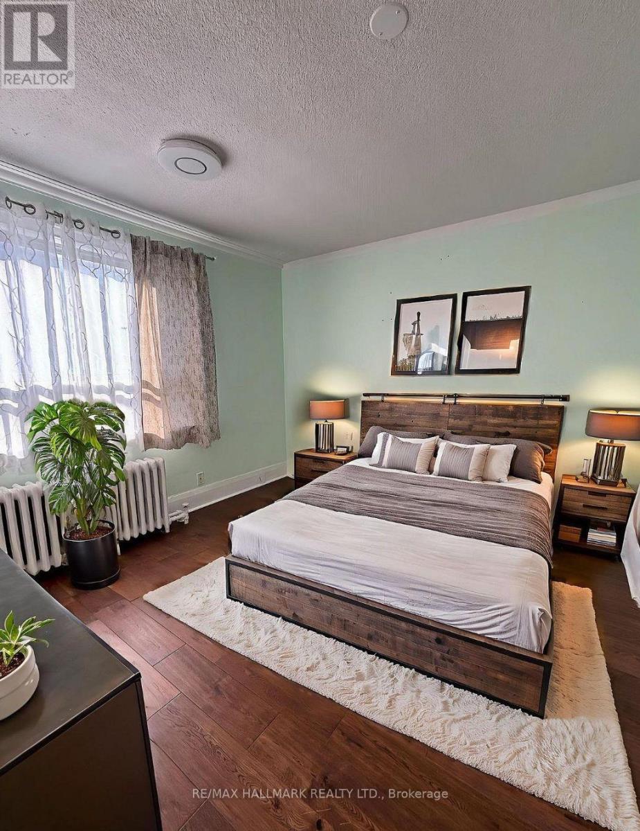 A bedroom with a large bed and a window with a plant in front of it.