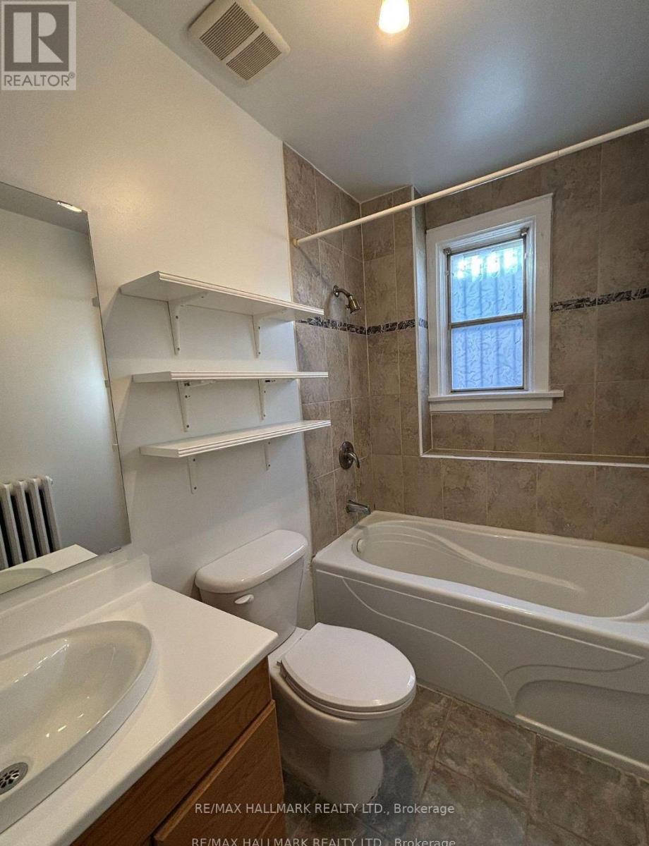A bathroom with a tub, toilet, and sink.