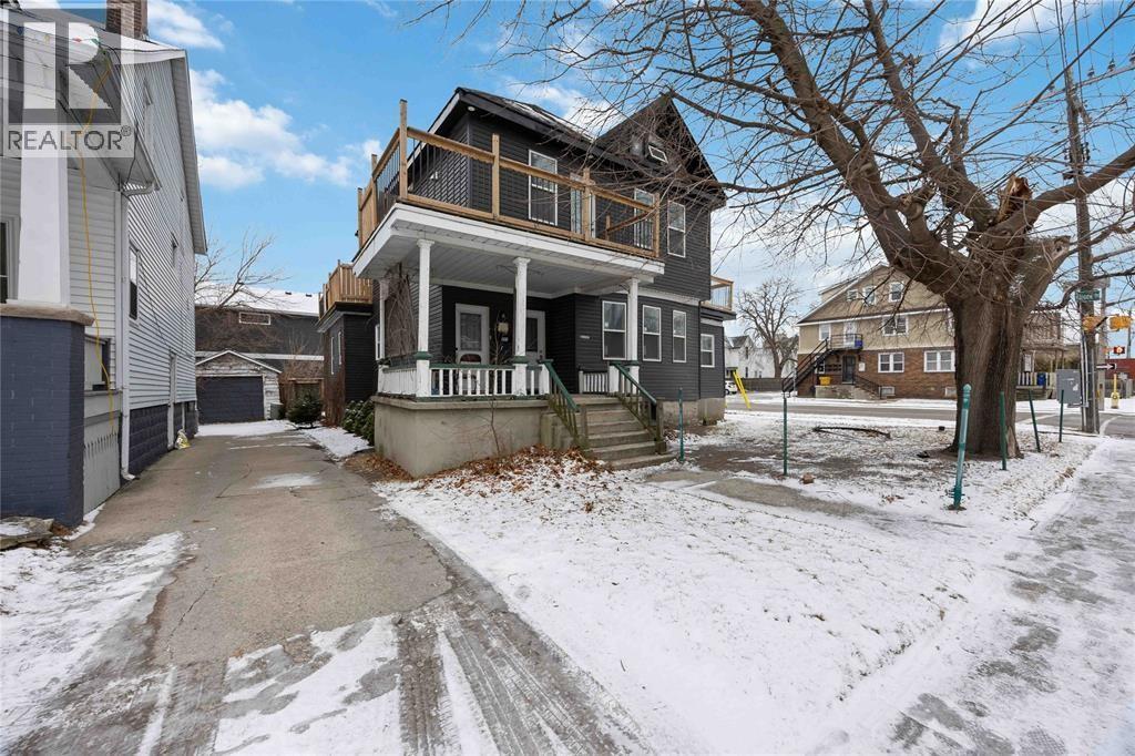 A house with a snow-covered driveway in front.