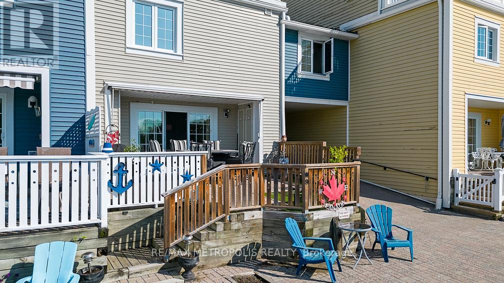 A small deck with chairs and a table is in front of a building.