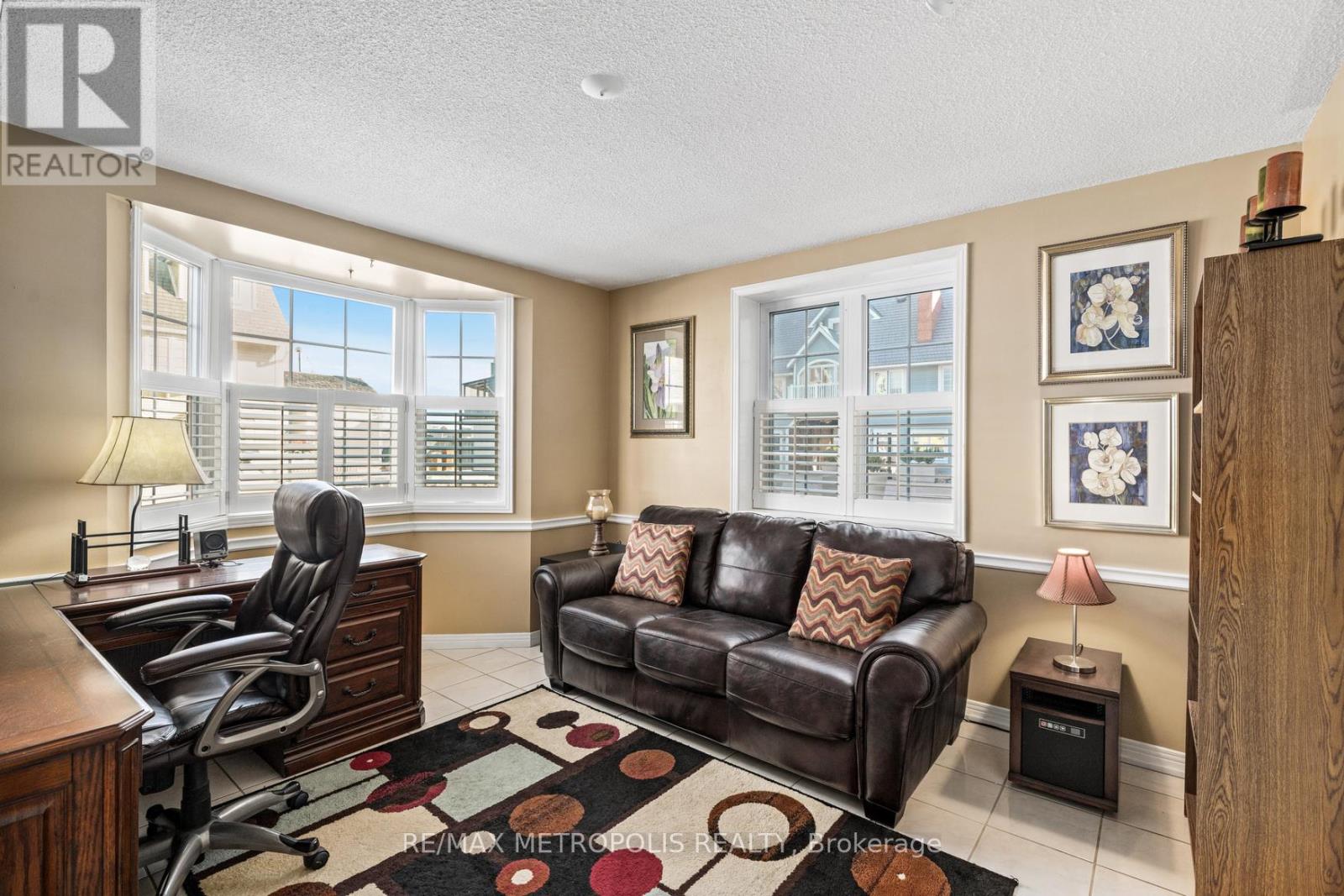 A living room with a brown couch and a desk.