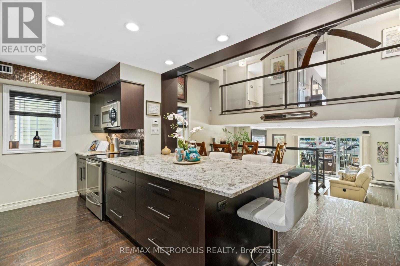 A modern kitchen with dark wood cabinets and a large island.