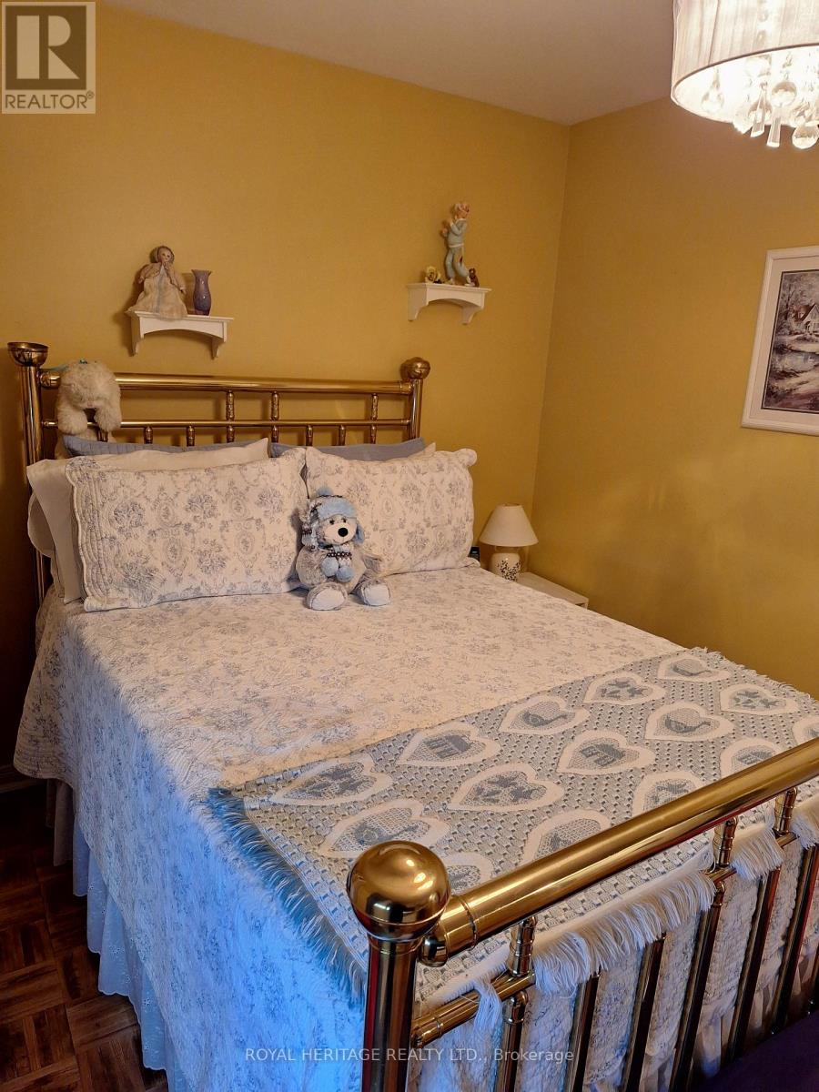 A bed with a blue comforter and a white pillow with a pattern on it.