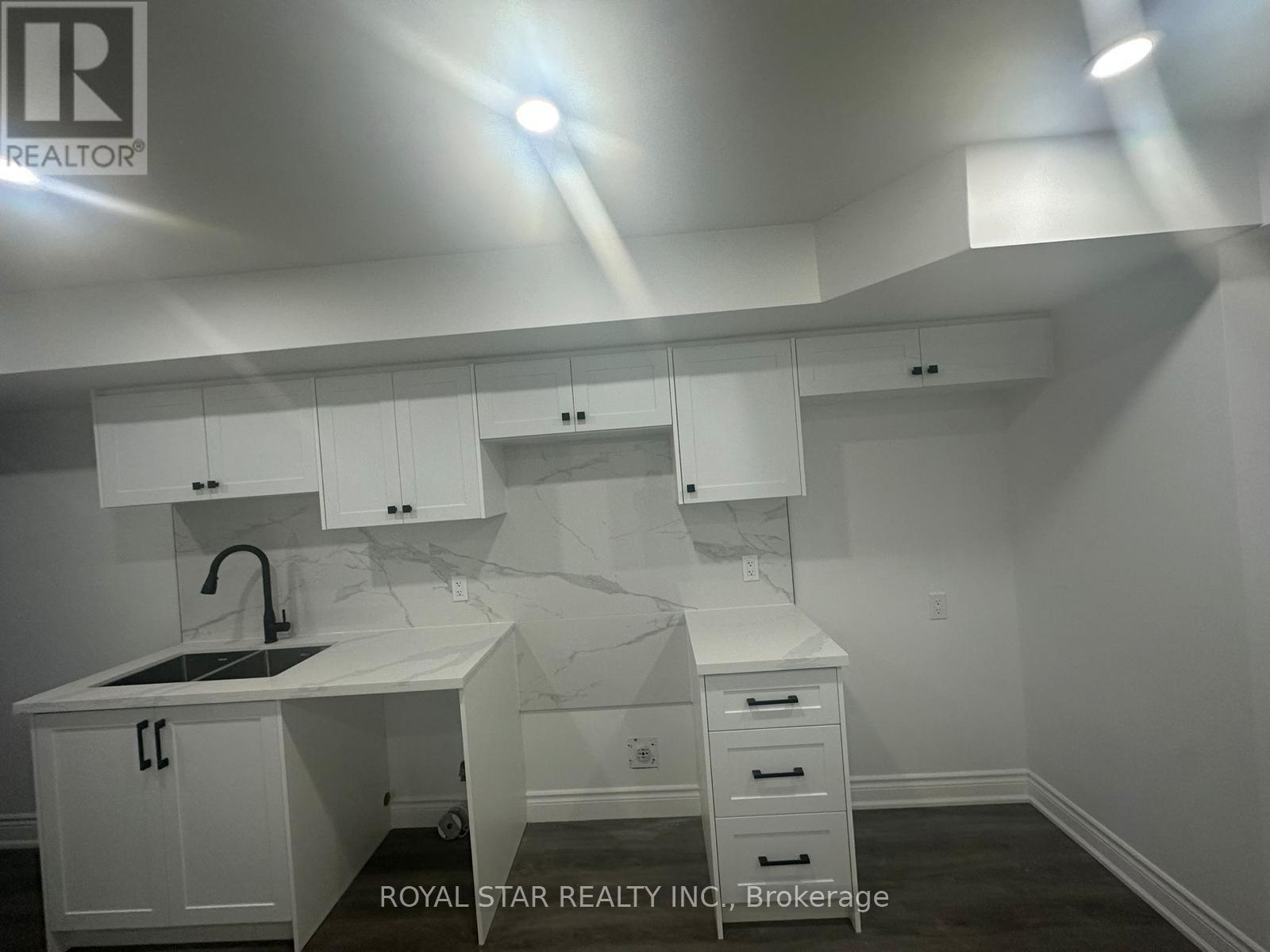 A white kitchen with a sink and cabinets.