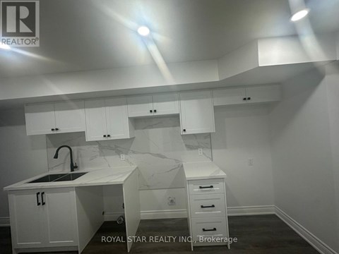 A white kitchen with a sink and cabinets.