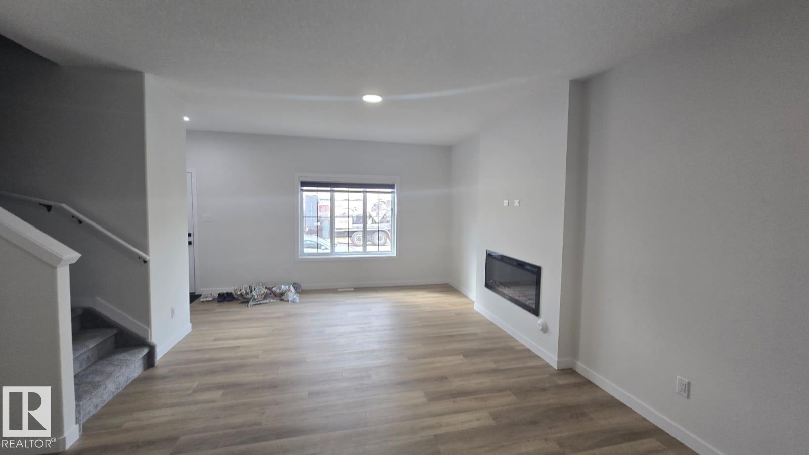 A modern living room with a fireplace and wooden flooring.