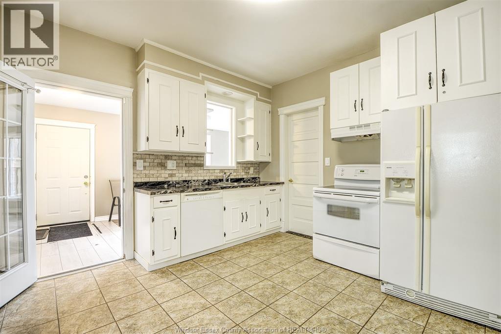 A kitchen with white appliances and cabinets.