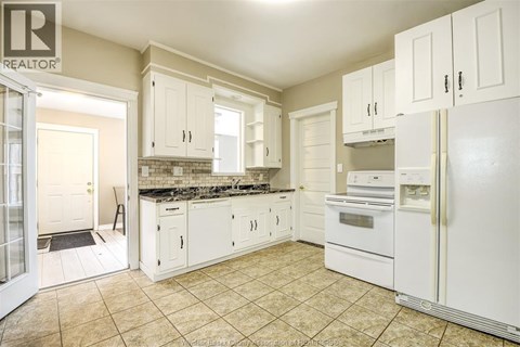 A kitchen with white appliances and cabinets.