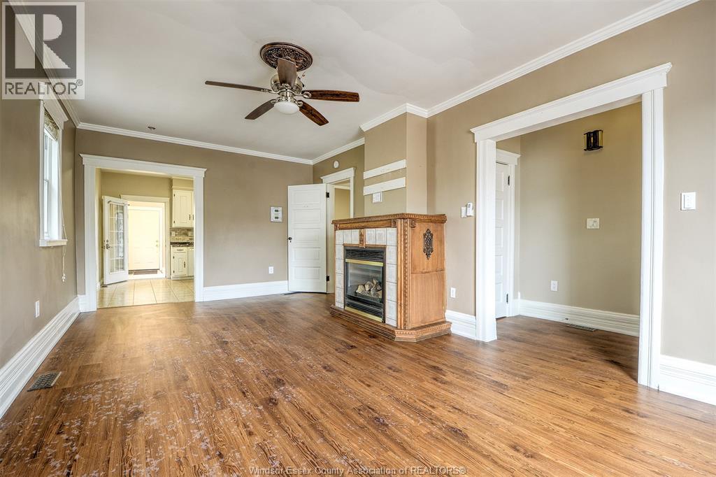 A spacious living room with wood flooring and a ceiling fan.