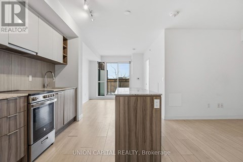 A modern kitchen with wooden cabinets and a stainless steel oven.