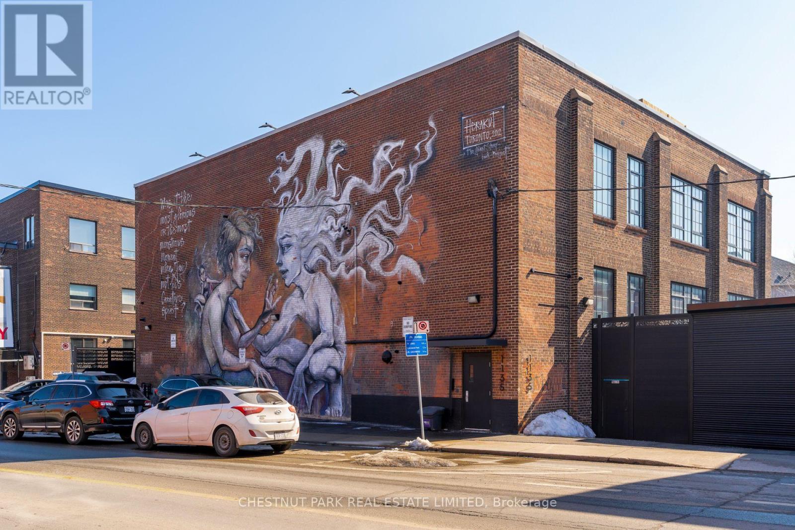 A large mural on a brick building with a woman and a dragon on it.
