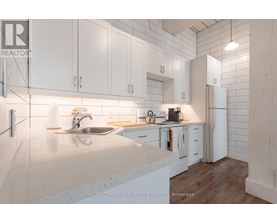 A modern kitchen with white cabinets and a marble countertop.