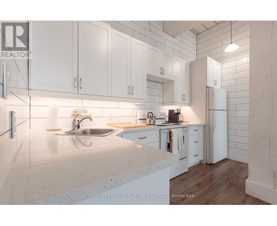A modern kitchen with white cabinets and a marble countertop.