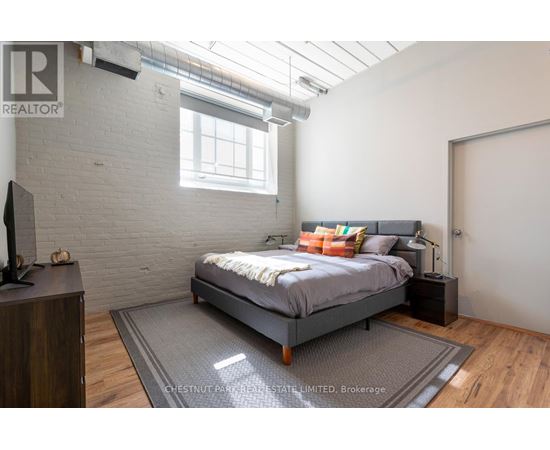 A bedroom with a bed, nightstand, and a tv.