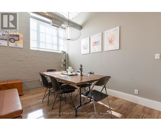 A dining room with a wooden table and chairs.
