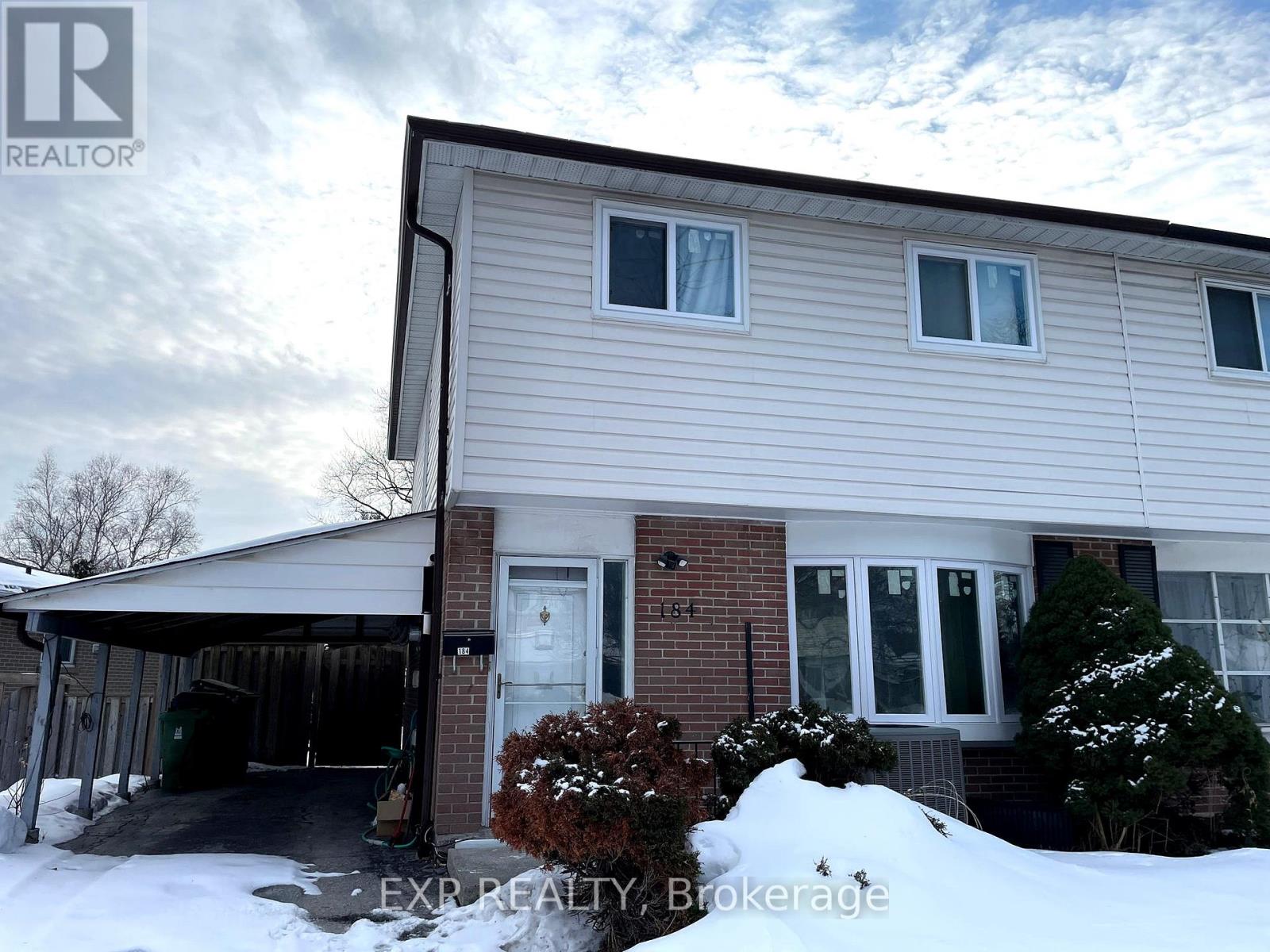 A house with a snow-covered ground in front of it.