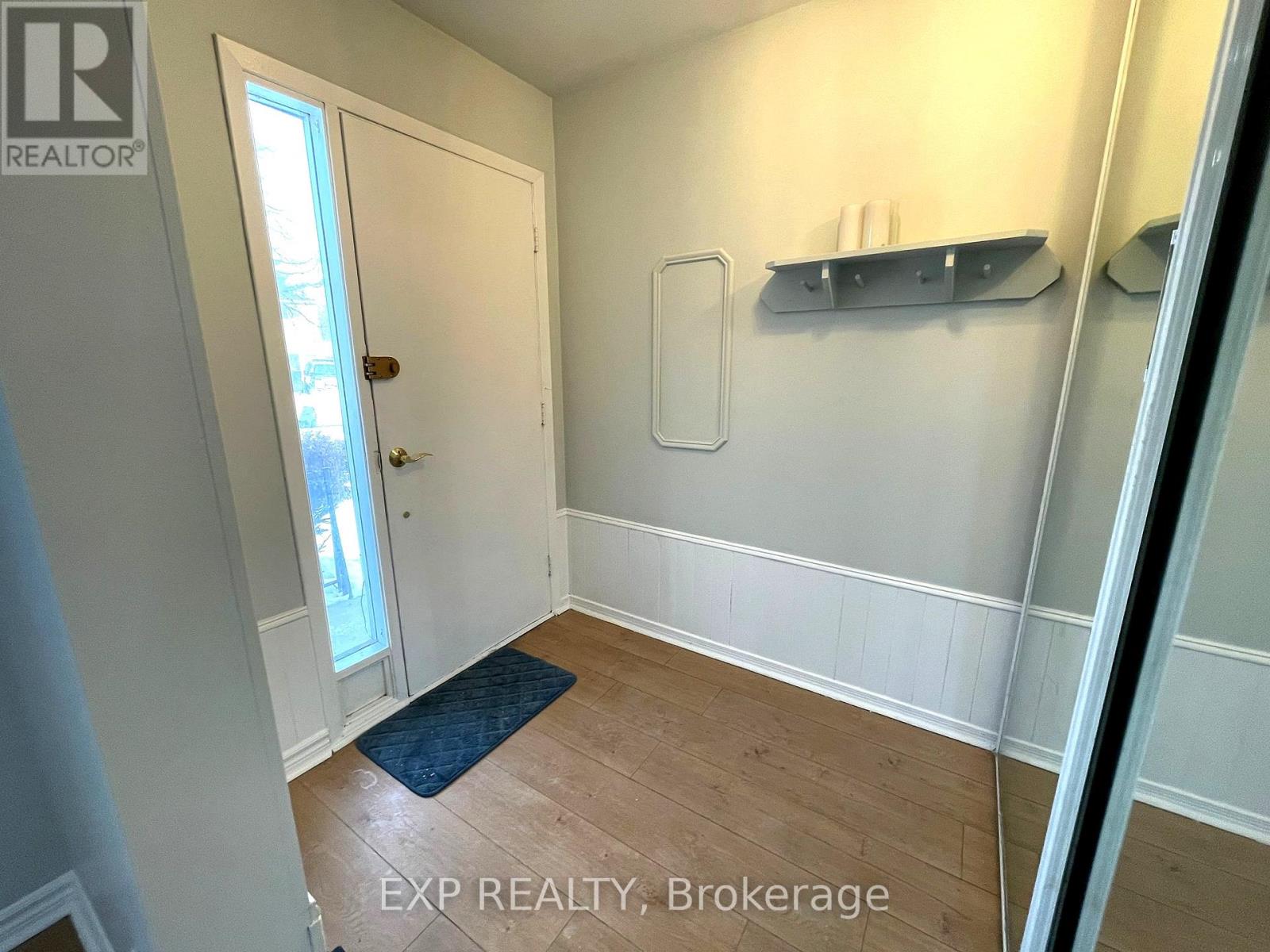 A room with a door and a shelf on the wall.