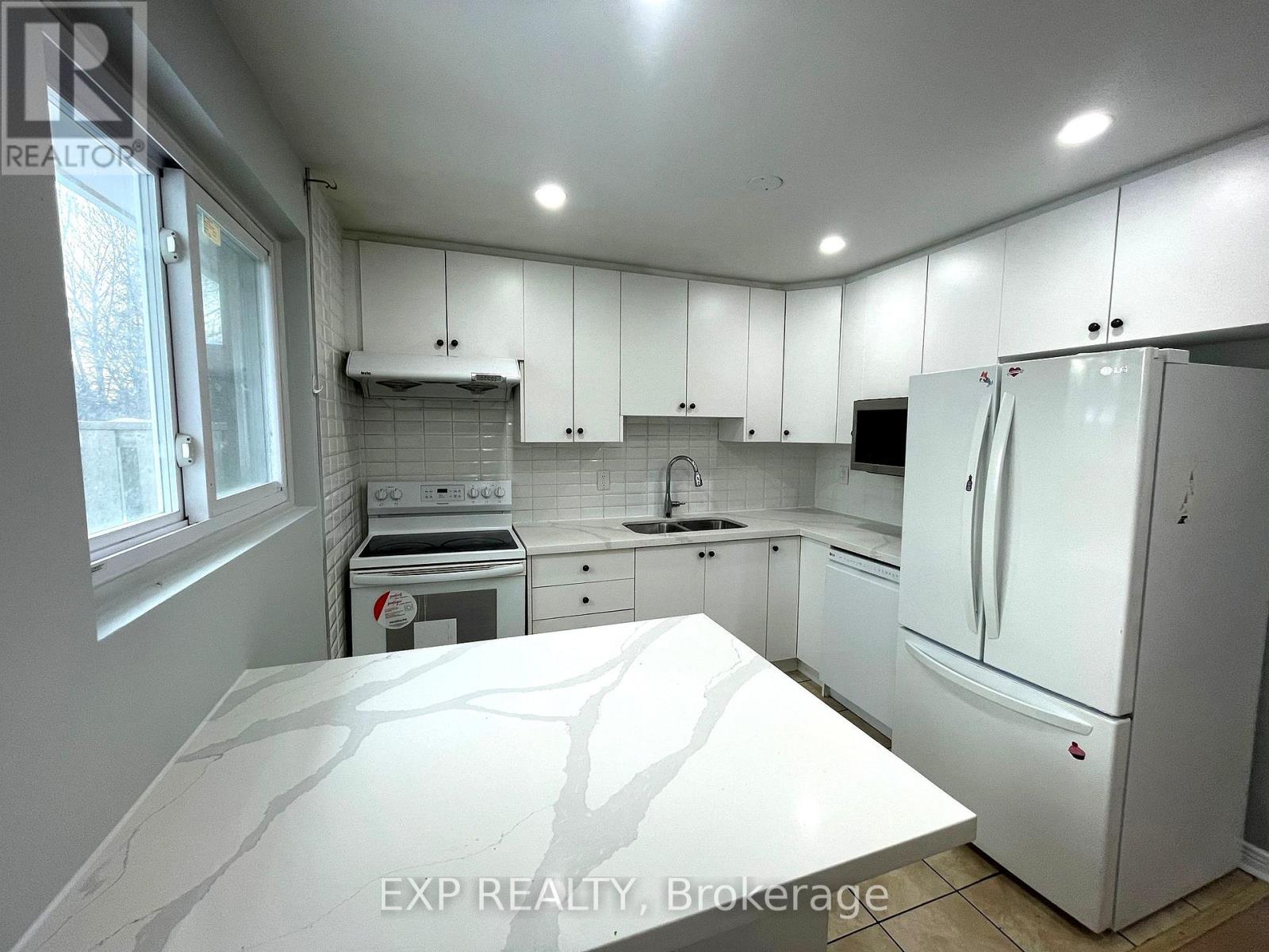 A kitchen with white cabinets and appliances.