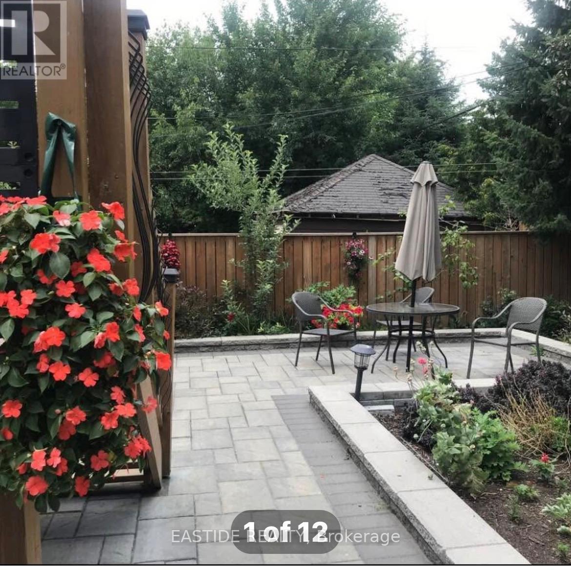 A patio with a table and chairs and a wooden fence.
