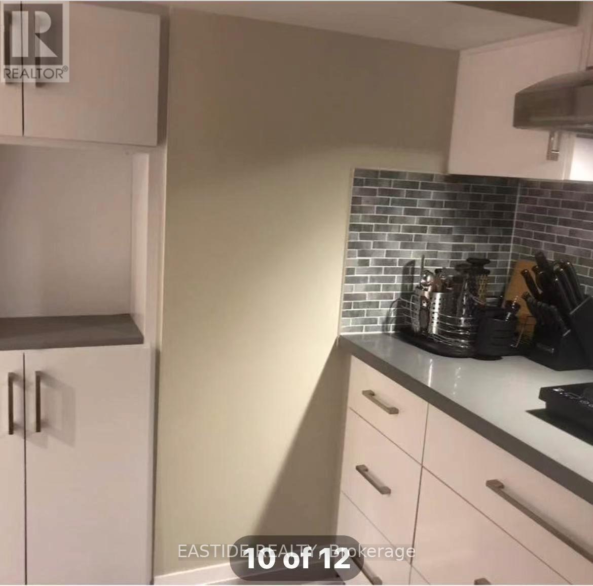 A kitchen with white cabinets and a black stove top.