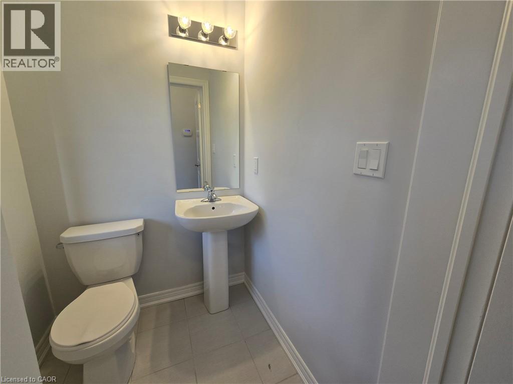 A white toilet and sink in a small bathroom.
