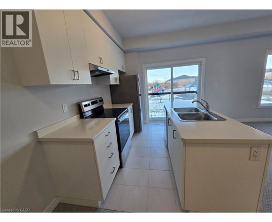A kitchen with white cabinets and a black oven.