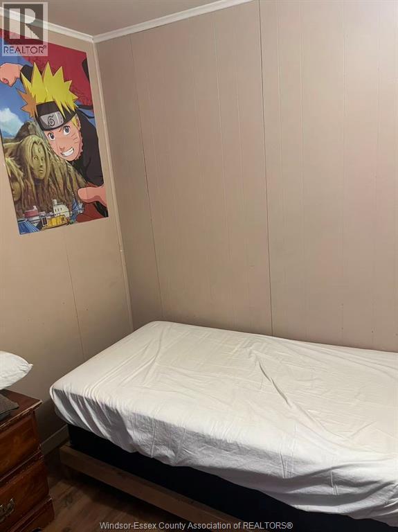 A bedroom with Naruto poster on the wall.