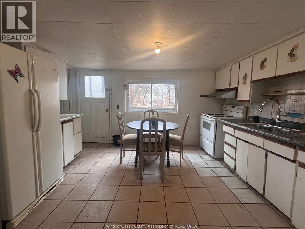 A kitchen with a table and chairs in the middle.