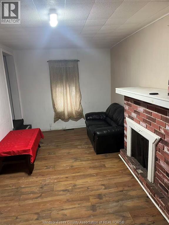 A living room with a red table and a black couch.