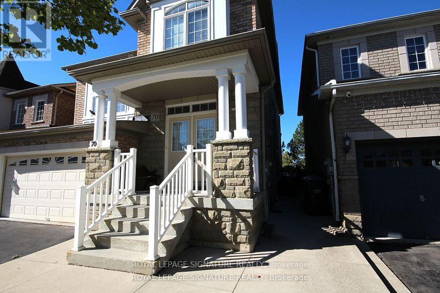 A house with a stone pillar and a white railing.