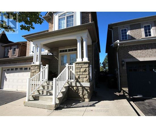 A house with a stone pillar and a white railing.