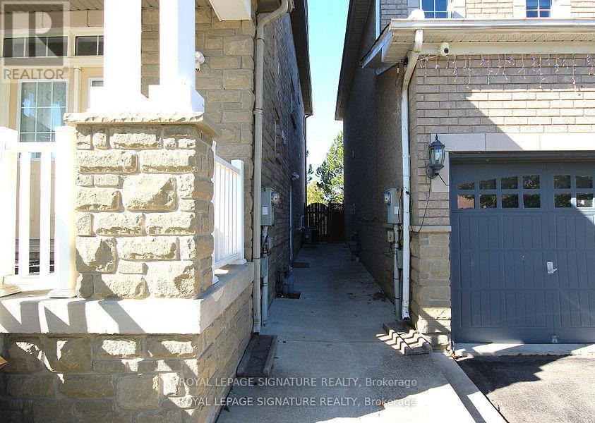 A narrow alleyway between two buildings with a garage door on the right.