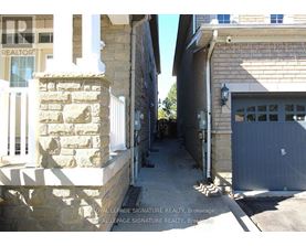 A narrow alleyway between two buildings with a garage door on the right.