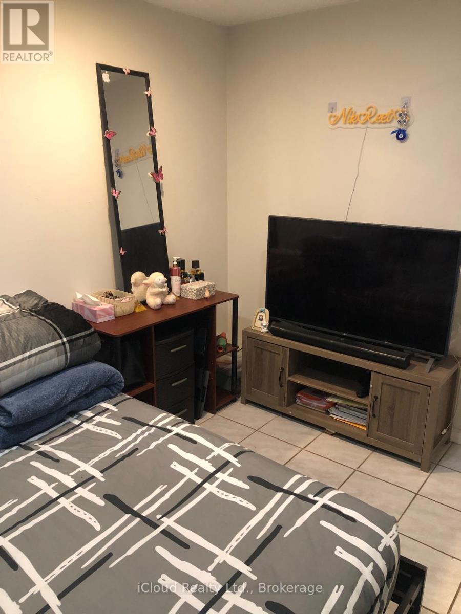 A bedroom with a bed, a dresser, a mirror, and a television.