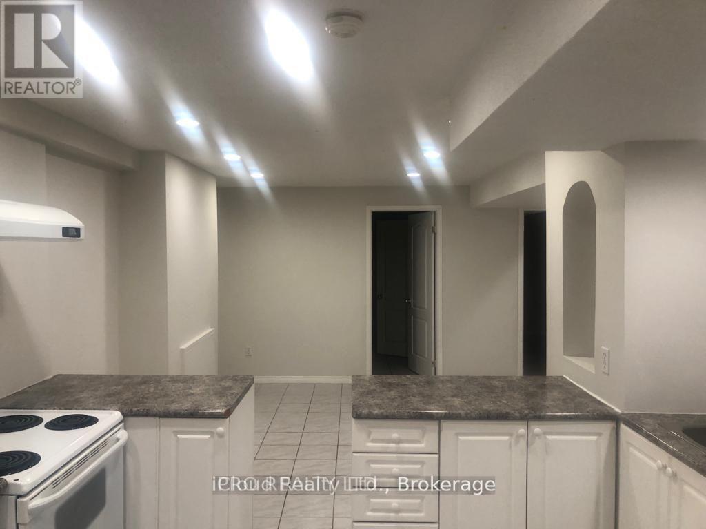 A kitchen with white cabinets and a stove top oven.