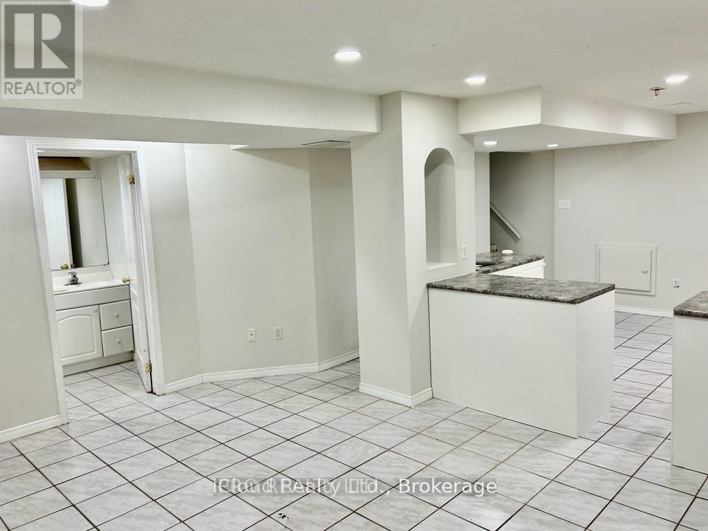 A realtor photo of a clean, empty living space with a kitchenette.