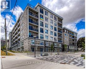 A large, modern apartment building with a stone facade and multiple balconies.