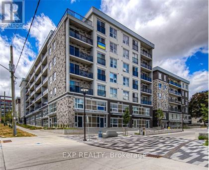A large, modern apartment building with a stone facade and multiple balconies.