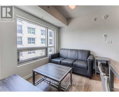 A living room with a black leather couch and a wooden coffee table.