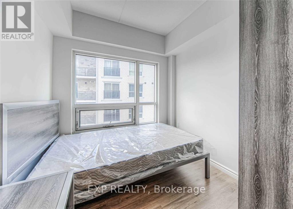 A bedroom with a large bed and a window overlooking a building.