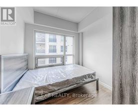 A bedroom with a large bed and a window overlooking a building.