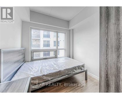 A bedroom with a large bed and a window overlooking a building.
