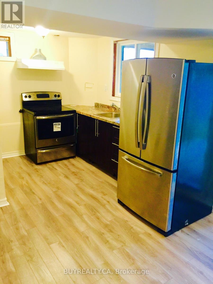 A modern kitchen with a stainless steel refrigerator and a black oven.