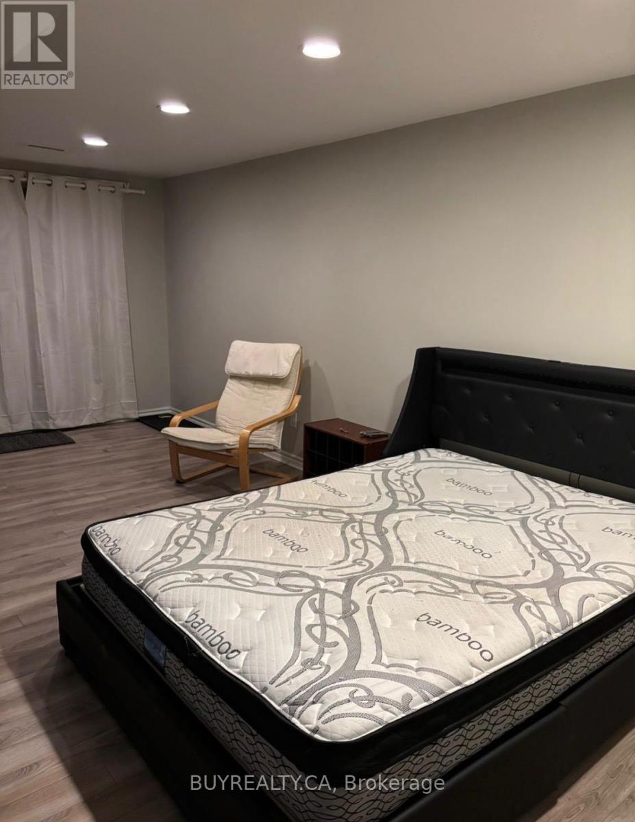 A bed with a Serta mattress is in a room with a chair.