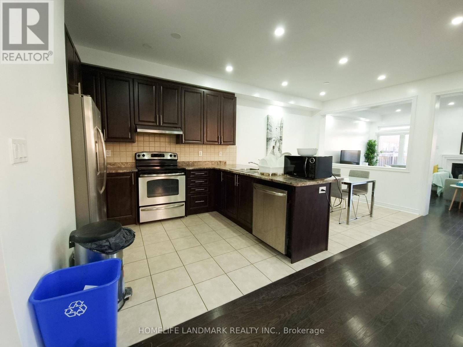 A kitchen with dark wood cabinets and a white stove top oven.
