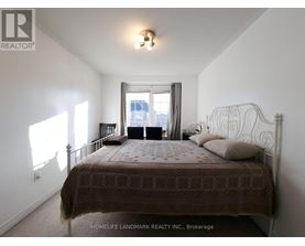 A bedroom with a large bed and a window letting in sunlight.